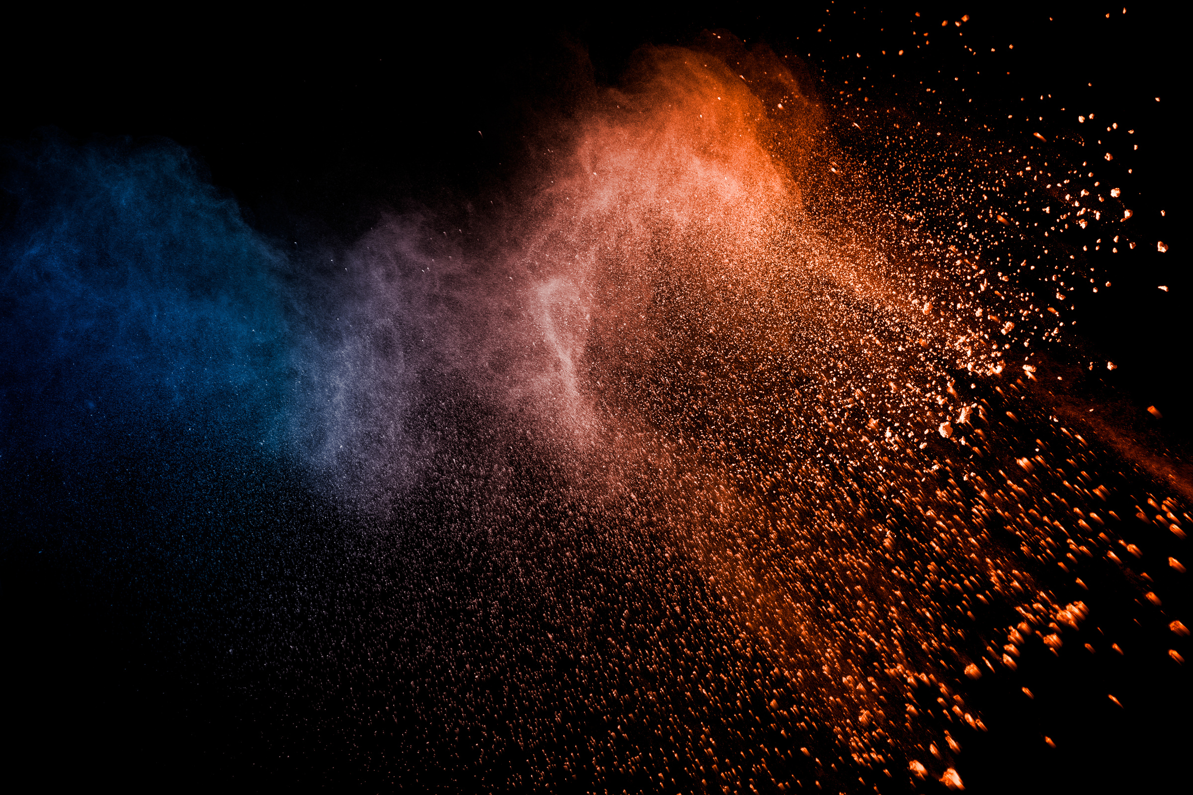 Orange blue  powder explosion on black background.Orange blue color dust splash clouds.
